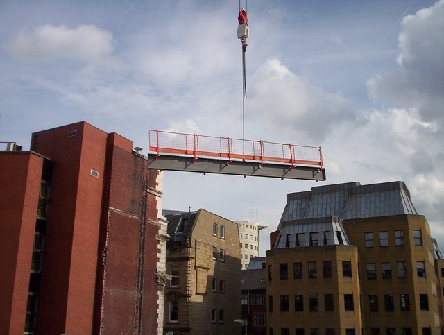 Steel beam being lifted into place by a crane