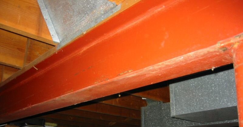 Painted steel I-beam spanning supports